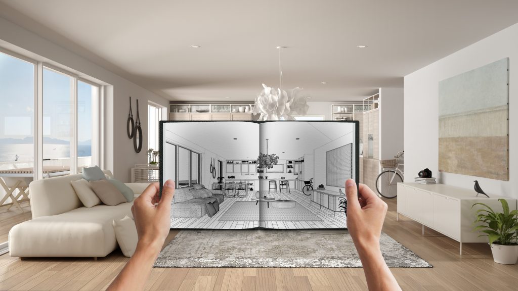 hands holding notepad with creative living room design blueprint