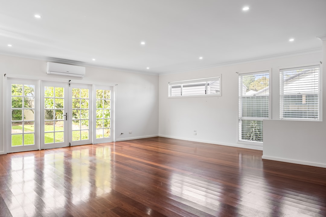 an-empty-living-room-with-hard-wood-floors-ek1mm9fmfuc