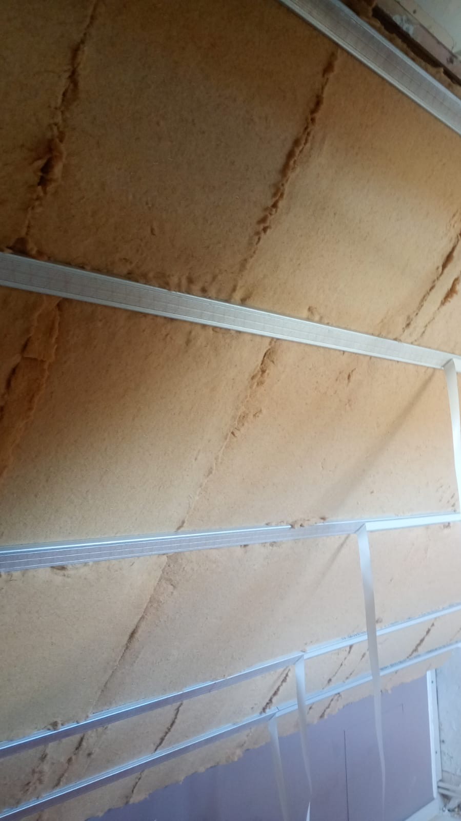 Pose des panneaux semi-rigides en fibre de bois entre les éléments de charpente